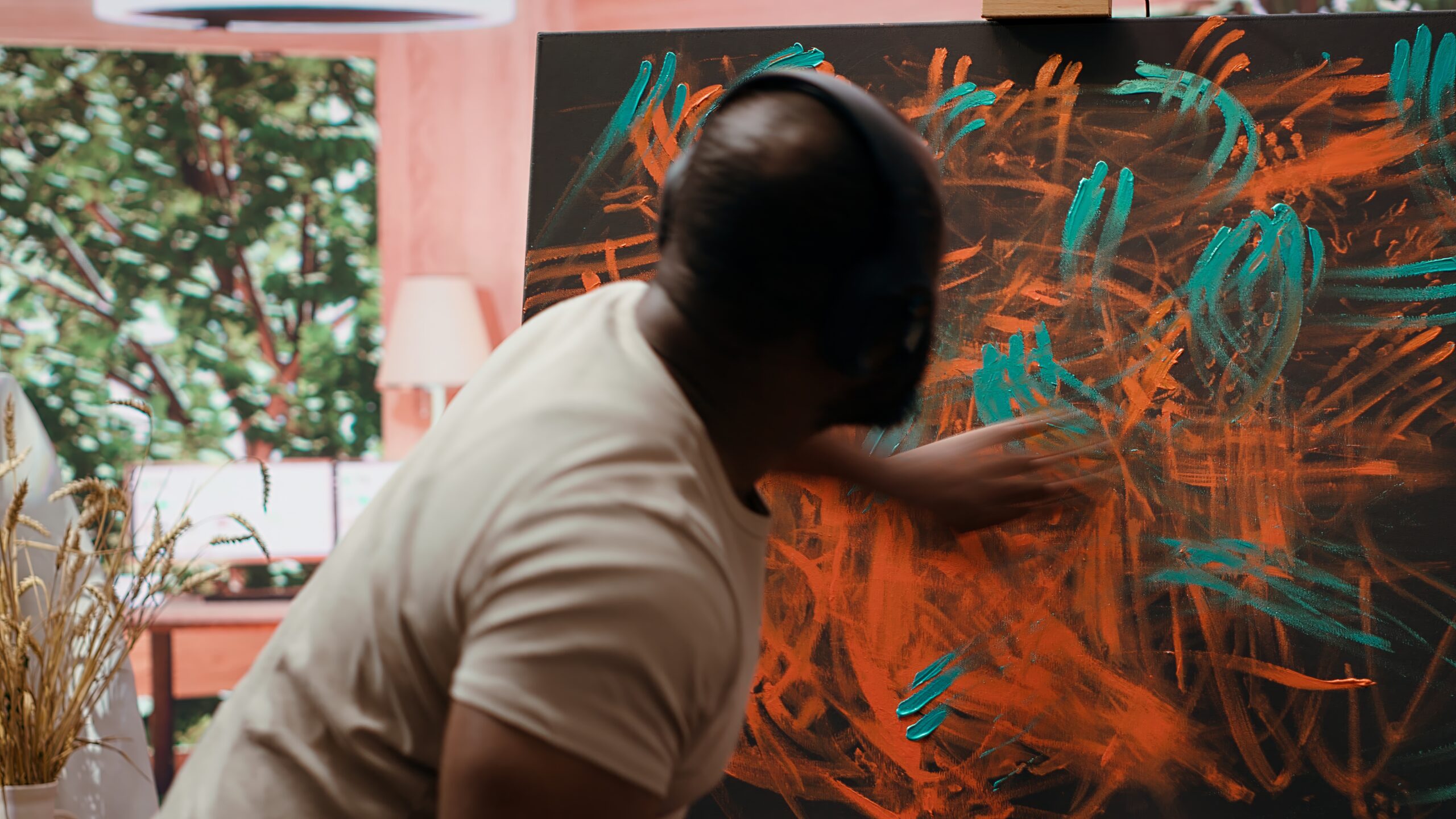 artist listening to music and creating an abstract painting with his fingers