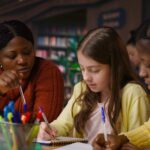 female teacher assisting pupils with class homework and mentoring